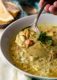 a person holding a spoon full of soup