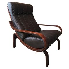 a black leather and wood lounge chair