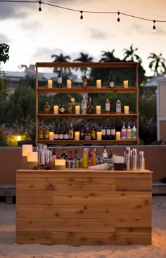 an outdoor bar with candles and bottles on it