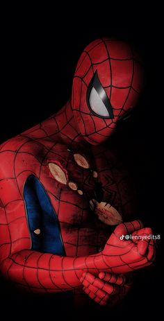 a close up of a spider man with his hands on his chest