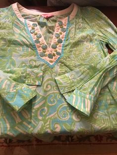 Awesome Lilly tunic blouse with blue/green tropical design as shown, with coordinating color discs sewn into the v-neck area trim. Excellent condition 100% cotton, and comfort slits on cuffs. size marked is Small and measurements shown in pics. price listed includes shipping. Cotton Vacation Blouse With Split Neck, Green Cotton V-neck Blouse, Beach Blouse With Split Neck In Cotton, Spring Green Cotton Tunic, Green Tunic Top For Vacation, Green Tunic Blouse For Vacation, Cotton Split Neck Tops For Beach, Green Cotton Summer Tunic, Cotton Long Sleeve Summer Tunic