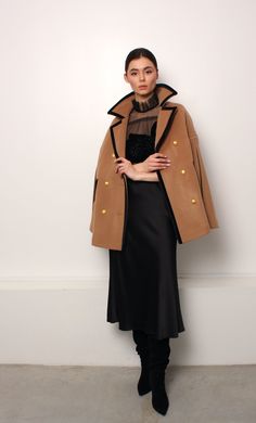 Timeless and elegant cape with velvet details and golden metal buttons with Mammu Couture logo. Cape is made of a high-quality double layered cashmere and wool blend and has a viscose lining. 10% cashmere, 90% wool Lining: 100% viscose Care: Dry cleaning only Evening Wool Outerwear With Buttons, Wool Evening Outerwear With Buttons, Luxury Formal Cape, Chic Evening Outerwear With Covered Buttons, Elegant Evening Outerwear With Gold Buttons, Elegant Outerwear With Gold Buttons, Luxury Cape For Fall, Elegant Pea Coat With Covered Buttons, Elegant Evening Cape For Winter