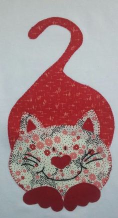 a red and white cat with flowers on it's head is sitting in the middle of a t - shirt