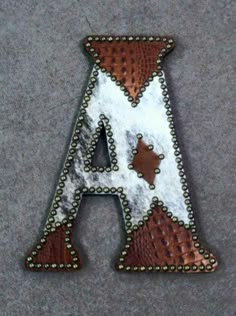 the letter is made out of leather and has metal studding on it's sides