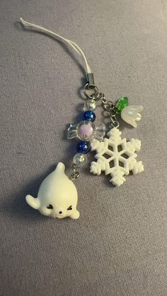 a close up of a key chain on a surface with snowflakes and charms