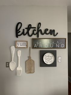 the kitchen wall is decorated with wooden spoons and utensils