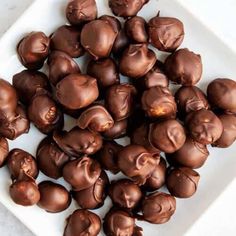 a white plate topped with chocolate covered donuts