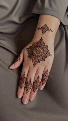 a woman's hand with henna tattoos on it