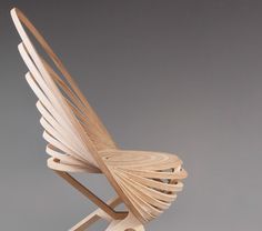 a wooden chair that is shaped like a bird's wing