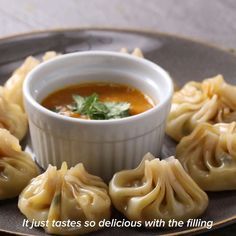 dumplings on a plate with dipping sauce in the middle and words that read, it just tastes so delicious with the filling