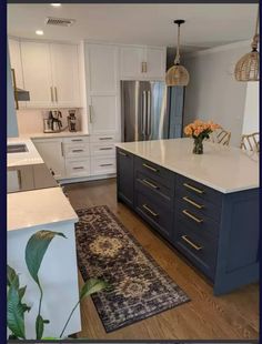 a kitchen with white cabinets and blue island