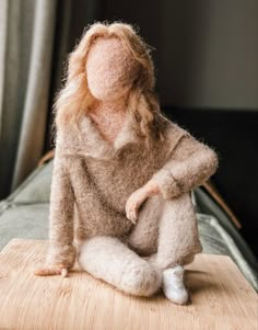 a doll sitting on top of a wooden table