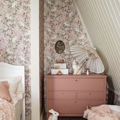 a bedroom with floral wallpaper and pink furniture