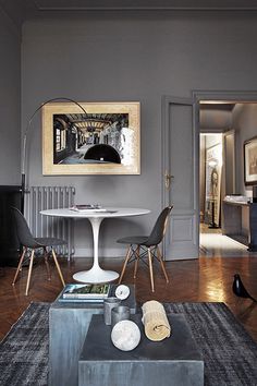 a living room filled with furniture and a painting hanging on the wall above a table