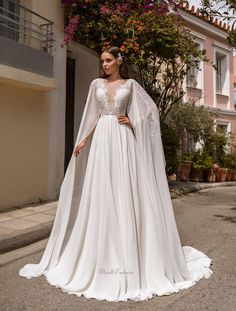 a woman in a white wedding dress standing on the street