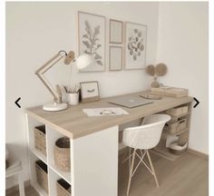 a desk with two chairs and a laptop on it in front of a white wall