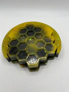 a yellow and black circular object on a white surface with lots of small speckles