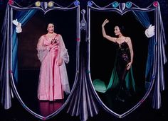 two women dressed in evening gowns standing next to each other with their arms raised