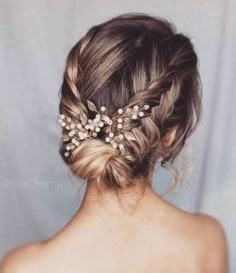 the back of a woman's head wearing a hair comb with pearls on it