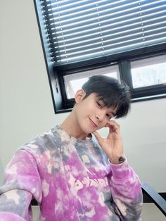 a young man sitting in front of a computer desk with his hand on his face