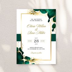 an elegant wedding card with gold and green leaves