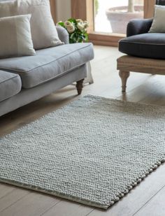 a living room area with couches, chairs and rugs