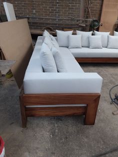 a white couch sitting on top of a wooden floor next to a pile of boxes