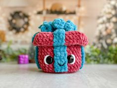 a crocheted toy with eyes sitting on top of a table