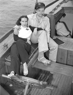 a man and woman sitting on the back of a boat