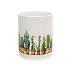 a white mug with cactus plants painted on it