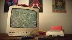 an old tv sitting on top of a wooden table next to a keyboard and mouse