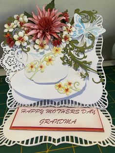 a mothers day card with flowers in a teacup on a doily tablecloth