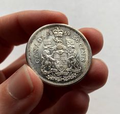 a person is holding a silver coin in their hand