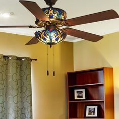 a ceiling fan with stained glass shades in a bedroom