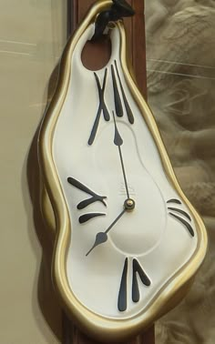 a clock that is on the side of a wall with black and gold trimmings