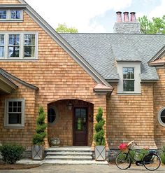 two bikes parked in front of a brick house with large windows on the second floor