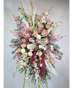 an arrangement of flowers and greenery in a vase