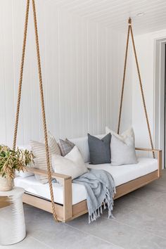 a white swing bed with pillows on it