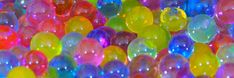 many different colored balloons are in the shape of balls and circles, as if they were floating or floating on water