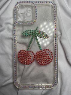 a phone case with some beads on it and two cherries attached to the back