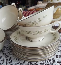 a stack of white dishes sitting on top of a table