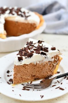 a piece of pie on a white plate with a fork in front of the slice