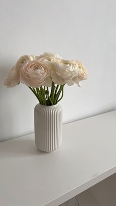 a white vase filled with flowers on top of a table