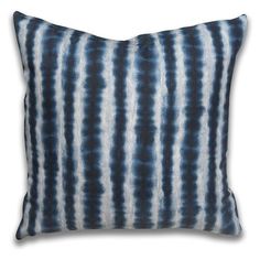 a blue and white pillow on a white background