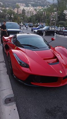 a red sports car is parked on the side of the road