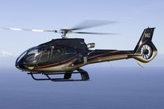 a helicopter flying over the ocean on a clear day