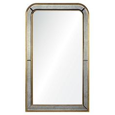 a gold framed mirror on a white wall