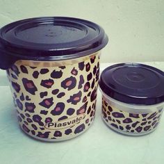 two plastic containers with lids are sitting on a table next to each other, one has a leopard print design