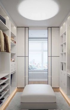 a walk in closet with white shelving and shelves