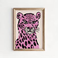 a pink and black leopard print in a wooden frame on the wall above a white wall